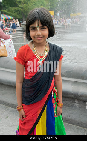 Ein 10 Jahre altes Mädchen aus Bangladesch in bunten Trachten im Washington Square Park in New York City. Stockfoto