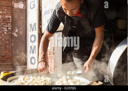 Bhaktapur, Nepal - 4. Dezember 2014: Mann Vorbereitung gedämpfte Momos in den Straßen Stockfoto