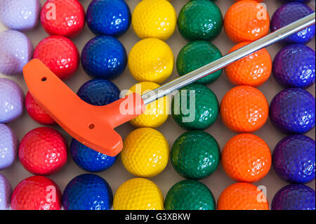 Orange Mini-Golf-Club mit einer Vielzahl von bunten Golfbälle Stockfoto