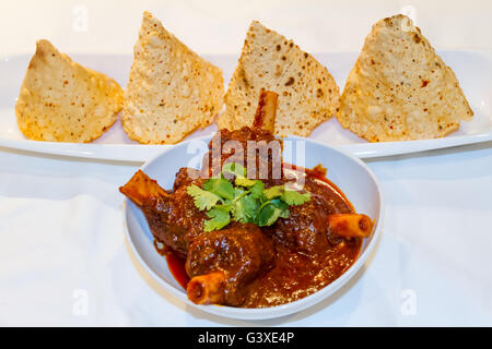 Rajasthani-Stil Hammelfleisch Curry und getrockneten stilvolle Papad auf dem Tisch. Stockfoto