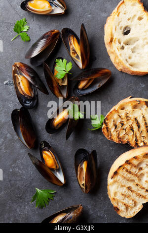 Muscheln und Brot Toasten am Steintisch. Ansicht von oben Stockfoto