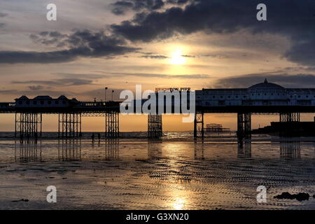 Eine tiefstehende Sonne an einem späten Frühjahr Nachmittag Silhouetten der beiden Pfeiler in Brighton. Stockfoto