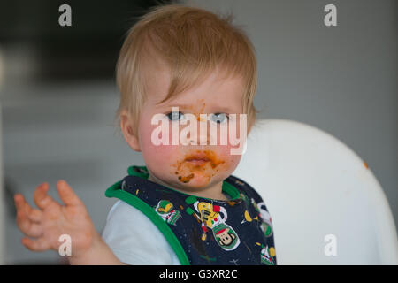 Kleinkind immer unordentlich, beim Abendessen essen Stockfoto