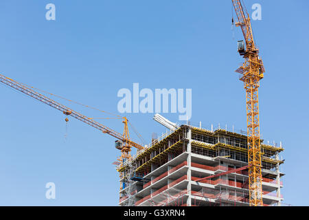 Eigentumswohnung-Turm im Bau mit zwei gelben Krane Stockfoto