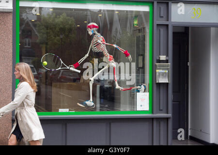 Wimbledon, London, UK. 16. Juni 2016. Ein Fußgänger geht Vergangenheit ein menschliches Skelett mit einem Tennisschläger eines Osteopathen als Wimbledon bereitet sich auf die 2016 Grass Court Tennis Turnier Credit: Amer Ghazzal/Alamy Live-Nachrichten Stockfoto