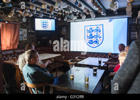 Llansaint, Carmarthenshire, Wales, UK. 16. Juni 2016. Wales und England Fans schauen Fußballspiel England gegen Wales im King's Arms Pub im Dorf Llansaint, Carmarthenshire, Wales. England, gewonnen, 2-1 zu gewinnen. England's Three Lions Emblem auf TV-Bildschirm vor Beginn der übereinstimmen. Alkohol, Bier, Stockfoto