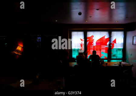 Aberystwyth, Wales, UK. 16. Juni 2016. Eine walisische Flagge hängt im Fenster einer Kneipe in Aberystwyth als Fans im Trübsinn sitzen, nach eine 2:1-Niederlage gegen England im heutigen EURO-Spiel Credit: Alan Hale/Alamy Live News Stockfoto