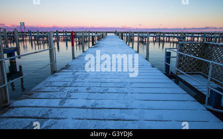 Winter auf den großen Seen. Schnee bedeckte Pier erstreckt sich auf Sonnenaufgang Horizont entlang der großen Seen in Michigan. Stockfoto