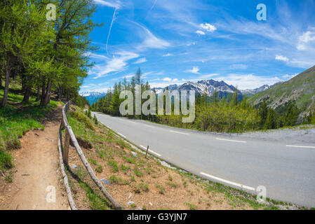 Zwei Lane Straße Kreuzung Bergen und Wäldern im malerischen Alpenlandschaft und stimmungsvoller Himmel, fisheye gepflastert. Sommer-Abenteuer und r Stockfoto