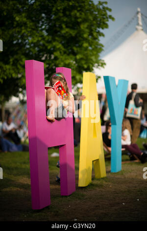 Besucher Besucher amüsieren sich mit eines der großen Zeichen auf dem Heu-Festival der Literatur und Kunst, Hay on Wye, Powys, Wales UK, Mai 2016 Stockfoto