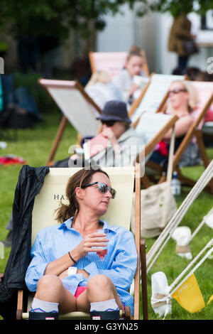 Leute sitzen in Liegestühlen Besuch Besucher amüsieren sich in die warmen Sonnenstrahlen am Hay Festival der Literatur und Kunst, Hay on Wye, Powys, Wales UK, Mai 2016 Stockfoto