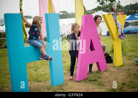 Besucher Besucher amüsieren sich mit eines der großen Zeichen auf dem Heu-Festival der Literatur und Kunst, Hay on Wye, Powys, Wales UK, Mai 2016 Stockfoto