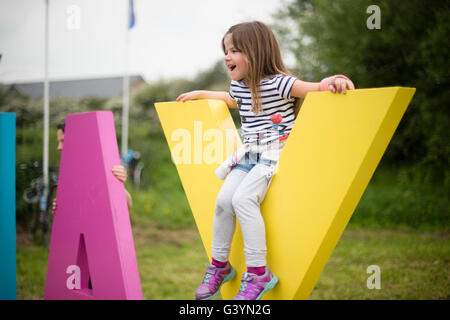 Besucher Besucher amüsieren sich mit eines der großen Zeichen auf dem Heu-Festival der Literatur und Kunst, Hay on Wye, Powys, Wales UK, Mai 2016 Stockfoto