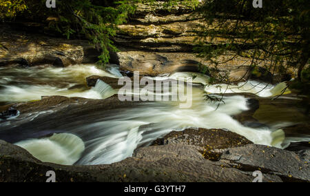 Porcupine Mountains State Park. Presque Isle Fluss schnitzt seinen Weg durch das Gestein, wie es in Richtung Lake Superior fließt. Stachelschwein Stockfoto
