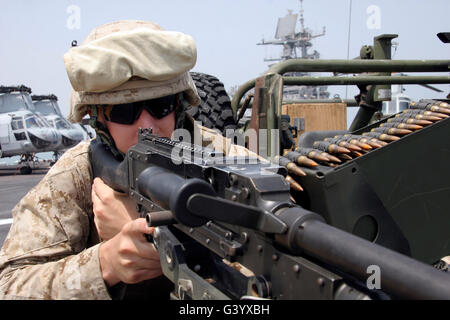 Eine Marine scannt den Horizont über die Websites von seinem Maschinengewehr M240G Medium. Stockfoto