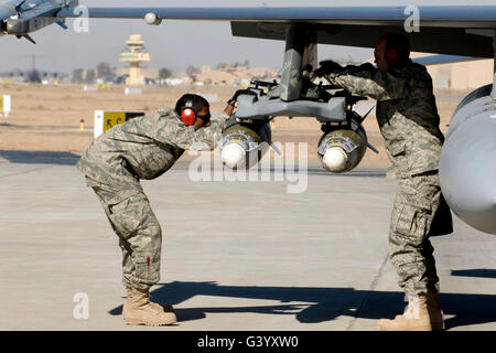 Flieger inspizieren f-16 Fighting Falcon Munition vor dem abheben. Stockfoto