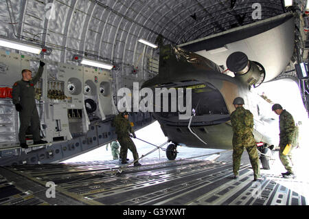 Eine CH-47J Chinook ist ein c-17 Globemaster III Transportflugzeug verladen. Stockfoto