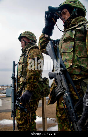 Zwei Mitglieder des Japan Ground Self-Defense Force wachen über einen bestimmten Bereich. Stockfoto