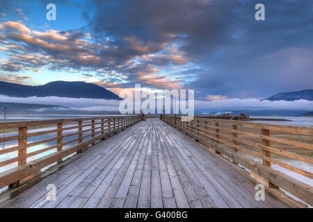 HDR-Rendering von Salmon Arm wharf an einem bewölkten Morgen bei Sonnenaufgang, mit Log Nebel am Horizont. Es ist der längste hölzerne Wharf in Stockfoto