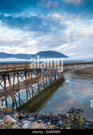 Salmon Arm Wharf an einem bewölkten Morgen bei Sonnenaufgang, mit niedrigen Nebel am Horizont. Es ist der längste hölzerne Wharf in Nordamerika. V Stockfoto