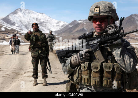 Soldat der US-Armee führt eine Patrouille mit einem Zug von Soldaten der afghanischen Nationalarmee. Stockfoto