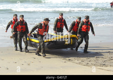 Basic Underwater Demolition/SEAL-Studenten bringen ihr Boot aus dem Wasser. Stockfoto