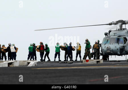 Matrosen und Marinesoldaten laden Lieferungen auf ein HH - 60H Seahawk. Stockfoto