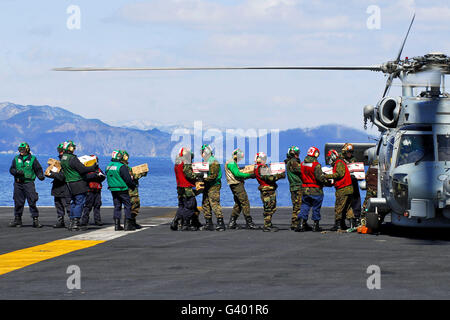 Matrosen und Marinesoldaten laden Lieferungen auf ein HH - 60H Seahawk. Stockfoto