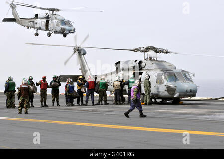 Personal laden Hilfsgüter auf eine SH-60F Sea Hawk-Hubschrauber. Stockfoto