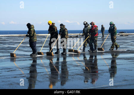 Seeleute schrubben das Flugdeck an Bord des Flugzeugträgers USS Ronald Reagan. Stockfoto