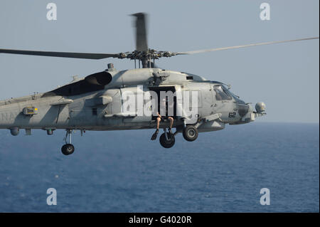 Ein Rettungsschwimmer bereitet aus einer SH-60 b Sea Hawk zu springen. Stockfoto