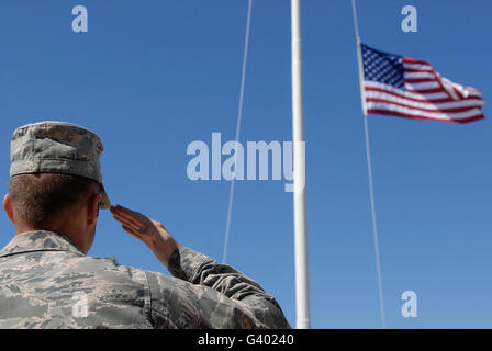 Ein Soldat grüßt die amerikanische Flagge. Stockfoto