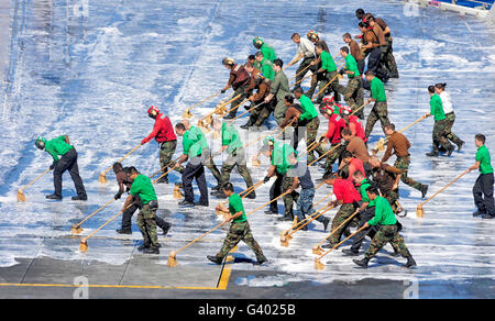 Matrosen führen ein Flugdeck Wash-down an Bord des Flugzeugträgers USS George Washington. Stockfoto