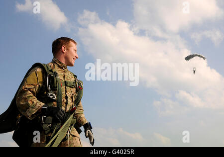 Ein Fallschirmjäger schaut auf als andere Fallschirmjäger Fallschirm in Cheongju, Südkorea. Stockfoto