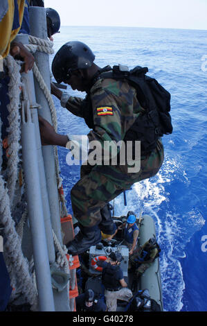 Ein Marine aus Uganda Peopleâ€™ s Defense Force senkt sich ein Schiff der US-Marine. Stockfoto