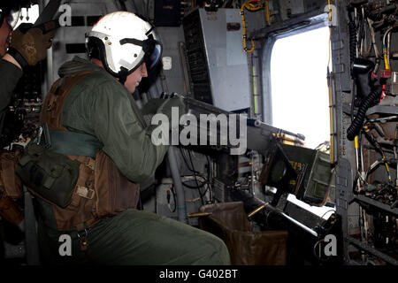 Crew Chief feuert ein M2.50-Kaliber-Maschinengewehr aus einer CH-53E Super Stallion. Stockfoto