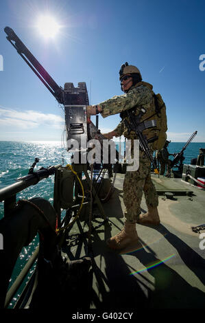 Kanonier mans eine M240-Maschinengewehr auf einem Fließgewässer Befehl Boot. Stockfoto