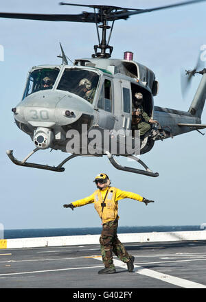 Ein Flieger löscht das Flugdeck vor dem Start eines UH-1N Huey Hubschraubers. Stockfoto