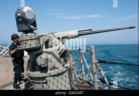 Gunner es Mate soll eine 25mm Chain Gun an Bord USS Cape St. George. Stockfoto