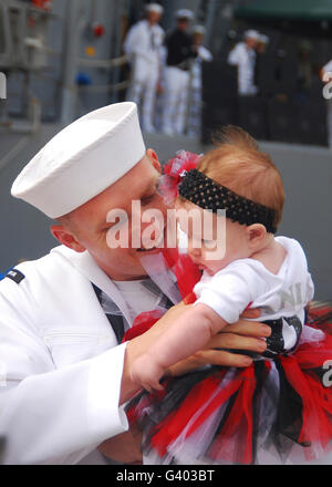 US Navy Sailor umarmt seine Tochter während der Heimkehr. Stockfoto