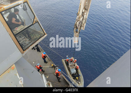 Matrosen zurück zu ihrem Schiff in einem Festrumpf Schlauchboot. Stockfoto
