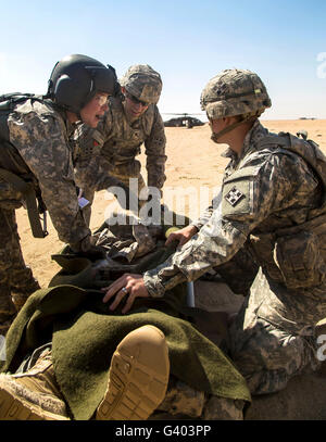 Soldaten bereiten einen verwundeten Soldat auf einem UH-60 Black Hawk zu laden. Stockfoto