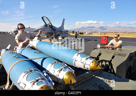 US Air Force Piloten laden eine GBU-38 auf einen Waffen-Transport-Anhänger. Stockfoto