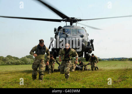 Soldaten zu montieren ein Zodiac-Schlauchboot am unteren Rand ein HH-60 Pave Hawk. Stockfoto