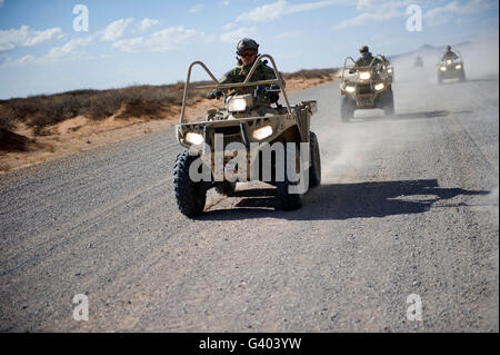 US-Soldaten Manöver auf einem Schotterweg mit einer LTATV. Stockfoto