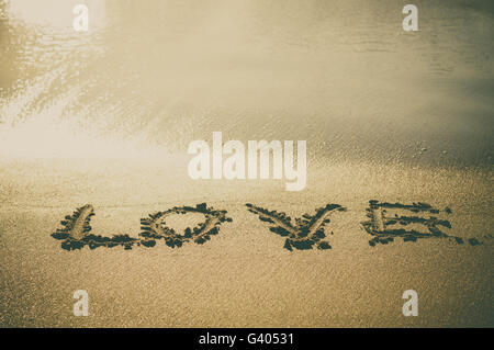 Liebe Text schrieb am Strand in der Nähe von Meerwasser, Sand Vintage Instagram getönten Bild Stockfoto