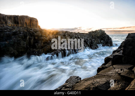 Bewegungsunschärfe bei Sonnenaufgang über Bombo Steinbruch Landspitze, Kiama, Illawarra Küste, New South Wales, NSW, Australien Stockfoto