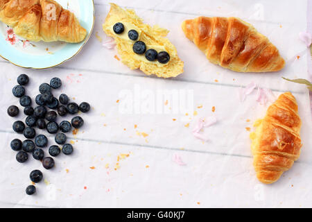 Leckeres Frühstück mit frischen Croissants und reifen Beeren auf alten hölzernen Hintergrund, selektiven Fokus Stockfoto