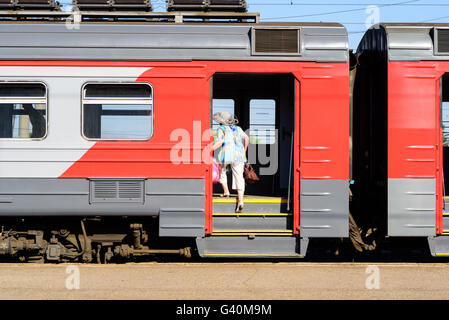 Eine ältere Frau besteigt die Russischen Eisenbahnen Kutsche Stillstand am Bahnhof Stockfoto