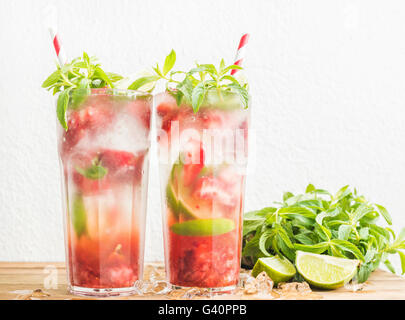 Erdbeer Mojito-Sommer-Cocktails mit Minze und Limette in hohe Gläser. Weiße Wand Hintergrund Stockfoto